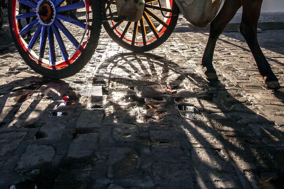 The wheels of a horse-drawn kalesa on the cobbles of Intramuros, Manila
